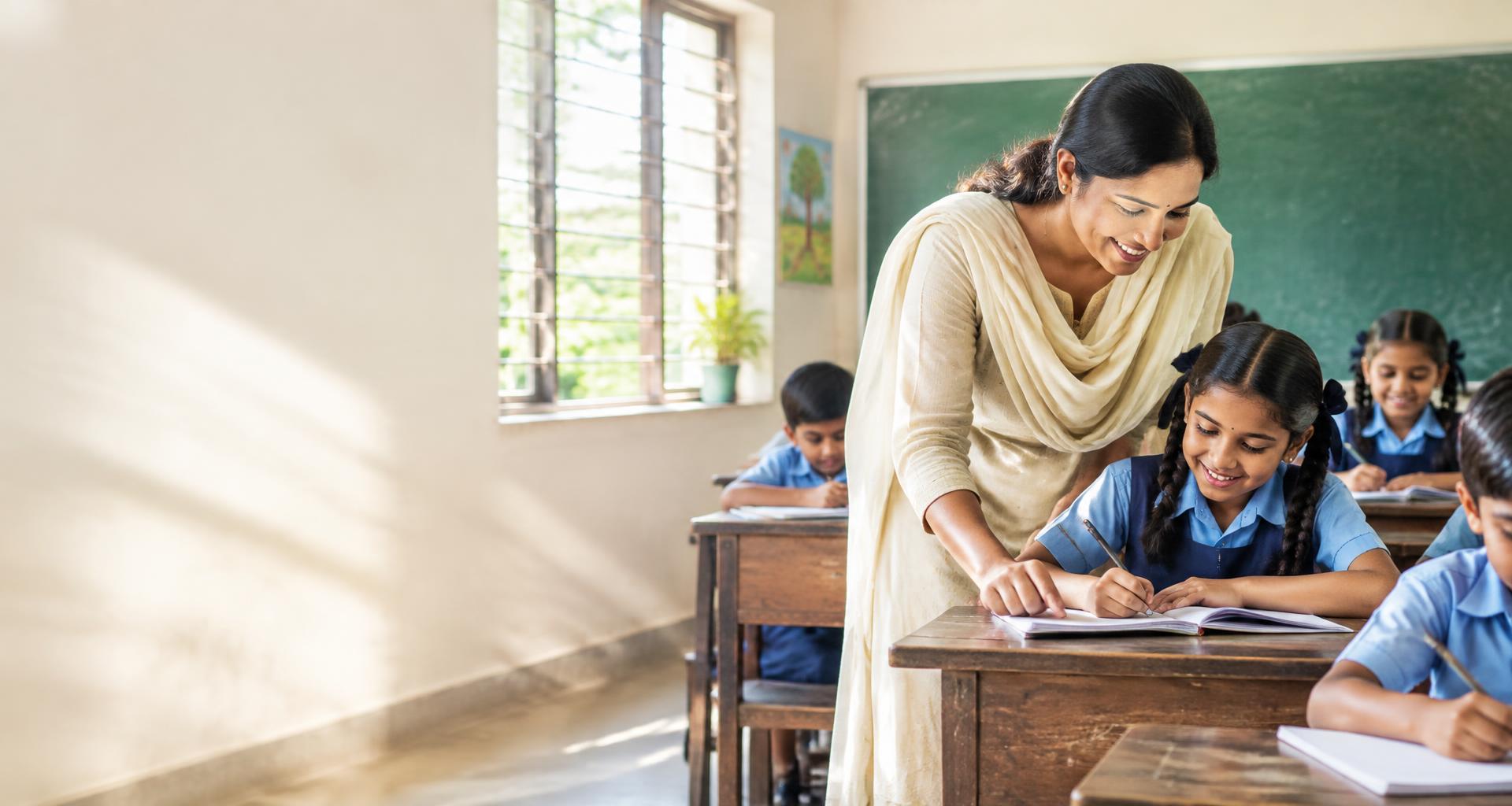 A teacher guiding a young student as she writes in an inclusive classroom